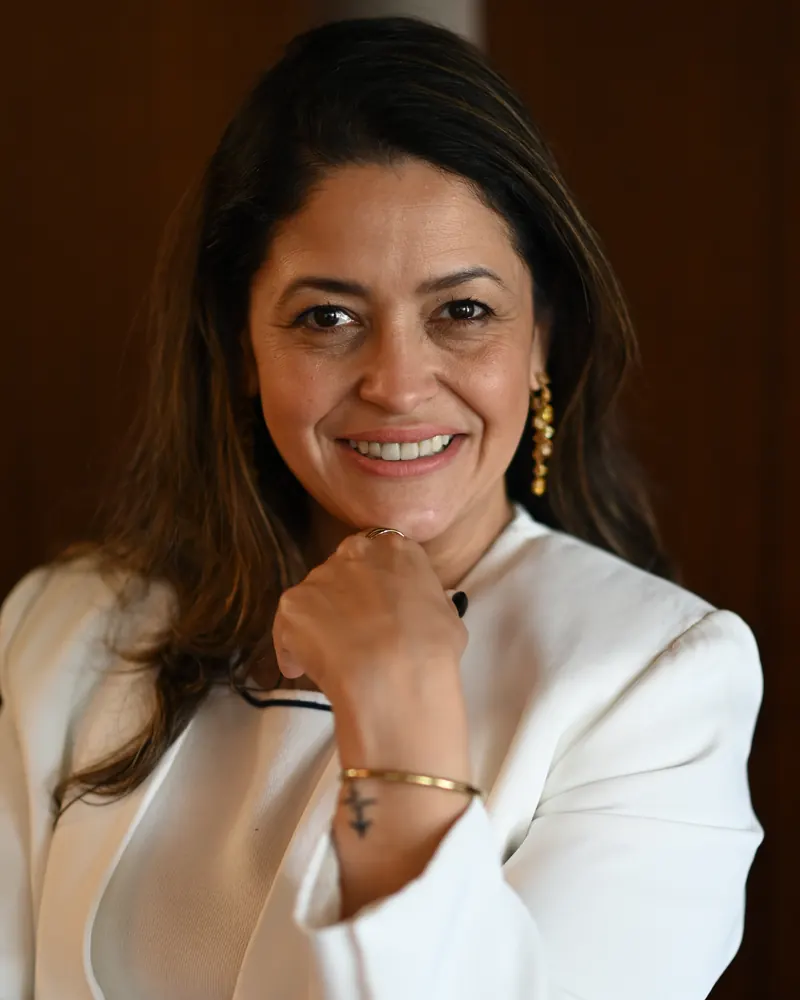 Ana Paula Leão, consultora imobiliária, de blazer branco, a sorrir para a câmara