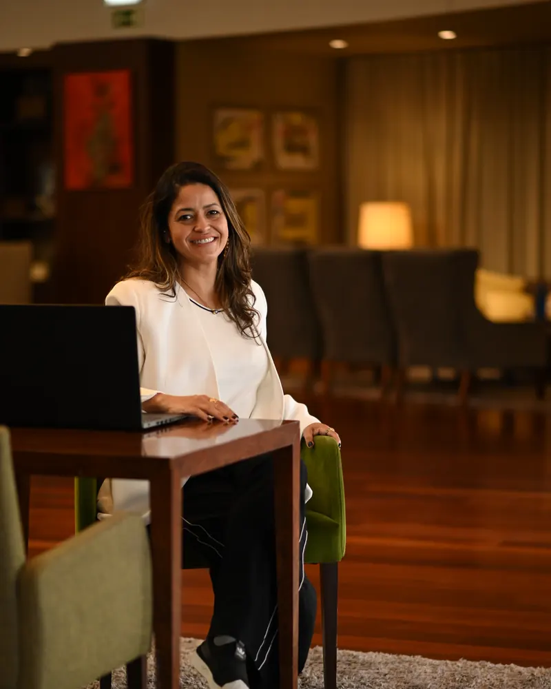 Ana Paula Leão sentada à secretária, a trabalhar no computador portátil